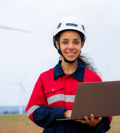 windmill engineer woman use laptop computer inspection and progress check wind turbine farm.